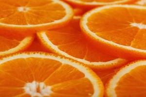 fatias de laranja madura retroiluminadas como fundo textural. tela cheia, close-up, macro