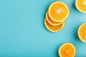 fatias redondas de laranja suculenta em um fundo azul, vista superior como um substrato de fundo. fundo de comida foto