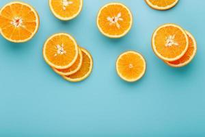 fatias e fatias de polpa de laranja em um fundo azul brilhante como fundo textural, o substrato. configuração plana em tela cheia, vista superior. fundo de comida foto