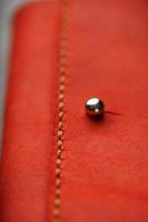 bolsa feita de couro vermelho genuíno, feito à mão em um fundo escuro. costuras costuradas. foto