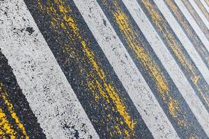 travessia de pedestres, listras amarelas e brancas no asfalto molhado na forma de textura e substrato foto