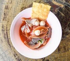 macarrão com frutos do mar na sopa vermelha quente e picante comida tailandesa macarrão lula carne de porco bolinha de peixe ipoméia crocante wonton pele carne de porco e cubos de sangue foto