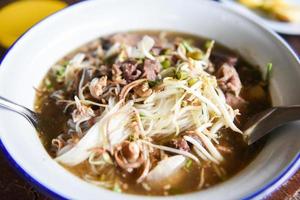 tigela de macarrão delicioso - sopa de macarrão aletria com ensopado de carne de porco vegetal na tigela comida tradicional tailandesa e chinesa da ásia, miudezas de porco, intestinos de fígado de porco foto