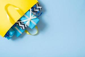 muitos presentes para o conceito de férias. presentes de natal com laços em uma sacola de presente em um fundo colorido foto