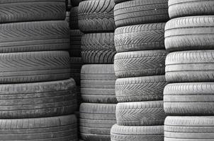 pneus usados velhos empilhados com pilhas altas na garagem da loja de peças de carro secundárias