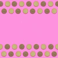 quadro de biscoitos marrons em um fundo rosa. conceito mínimo moderno de comida e sobremesa. postura plana abstrata, vista superior foto