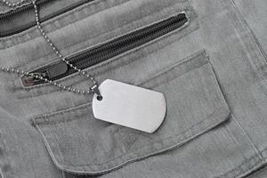 contas militares prateadas com placa de identificação no colete cinza escuro com bolsos foto