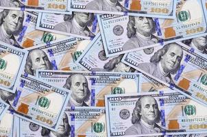 um grande número de notas de dólar americano de um novo design com uma faixa azul no meio. vista do topo foto