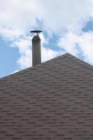 o telhado coberto com um revestimento impermeável betuminoso plano moderno sob um céu azul foto