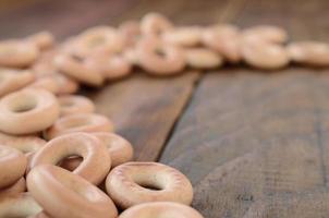 muitos bagels amarelos frescos estão na superfície da velha madeira escura. um tipo popular de produtos de farinha. uma das guloseimas tradicionais russas para o chá foto