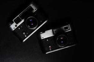 uma velhas câmeras fotográficas de meados do século 20 em fundo preto foto