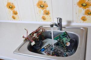 hardware na pia da cozinha sob o conceito metafórico de limpeza de computador de fluxo de água foto