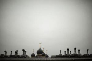 telhado da casa e cruz ortodoxa. vista do telhado na cidade. cidade russa em detalhes. tubos na construção. foto