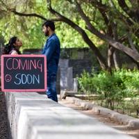 casal indiano posando para ensaio de maternidade. o casal está posando em um gramado com grama verde e a mulher está vacilando sua barriga no jardim lodhi em nova delhi, índia foto