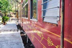 trem de brinquedo movendo-se nas encostas das montanhas, bela vista, uma montanha lateral, um vale lateral movendo-se na ferrovia para a colina, entre a floresta natural verde. trem de brinquedo de kalka para shimla na índia, trem indiano foto