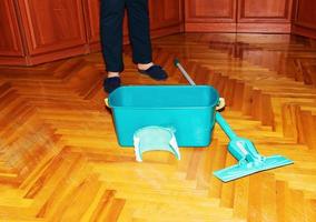 esfregue o chão de madeira. uma mulher prepara um esfregão. conceito de limpeza. foto