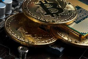 criptomoeda bitcoin dourada na cpu da placa de circuito do computador. tiro macro. foto