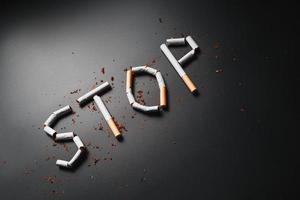 a inscrição para de cigarros em um fundo preto. Pare de fumar. o conceito de fumar mata. inscrição de motivação para parar de fumar, hábito pouco saudável. foto