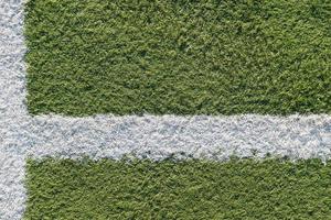 faixa branca no campo de futebol. textura verde de um campo de futebol, vôlei e basquete foto