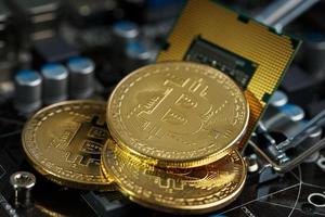 criptomoeda bitcoin dourada na cpu da placa de circuito do computador. tiro macro. foto