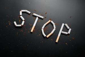 a inscrição para de cigarros em um fundo preto. Pare de fumar. o conceito de fumar mata. inscrição de motivação para parar de fumar, hábito pouco saudável. foto