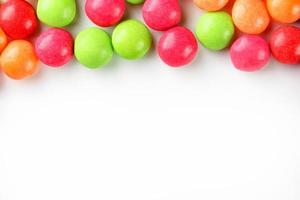 um arco-íris de cor de close-up de doces multicoloridos, drageia de esmalte multicolorida sobre um fundo branco foto