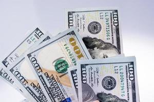 notas de 100 dólares americanas colocadas no fundo branco foto