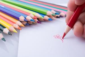 mão desenhando perto de lápis foto