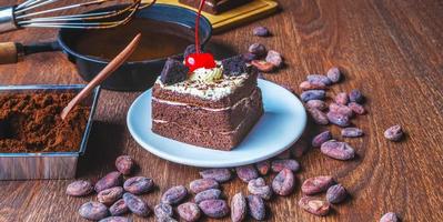 bolo de chocolate saboroso caseiro com frutas e padeiro ou chocolatier preparando chocolate mexendo o chocolate derretido com um batedor pingando na panela abaixo foto