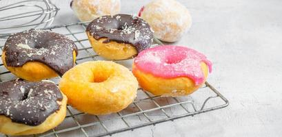 rosquinhas de chocolate e rosquinhas rosa na mesa da cozinha foto