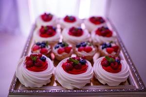 Barra de chocolate. mesa doce com merengue com frutas e bagas. delicioso buffet doce com bolos. buffet festivo com bolos e outras sobremesas. foco seletivo. foto