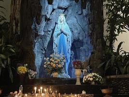 a caverna da virgem maria, estátua da virgem maria em uma capela de caverna de pedra igreja católica com vegetação tropical foto