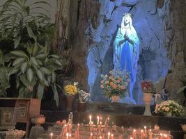 a caverna da virgem maria, estátua da virgem maria em uma capela de caverna de pedra igreja católica com vegetação tropical foto