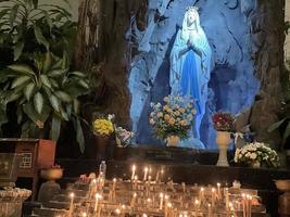 a caverna da virgem maria, estátua da virgem maria em uma capela de caverna de pedra igreja católica com vegetação tropical foto