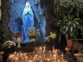 a caverna da virgem maria, estátua da virgem maria em uma capela de caverna de pedra igreja católica com vegetação tropical foto