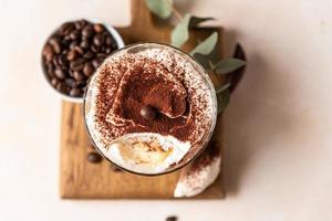 tiramisu de sobremesa italiana tradicional, fundo de pedra. Sobremesa porção sabor café feita de savoiardi e mascarpone decorada com cacau. foto