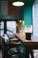 tiro vertical, close-up em um copo de cerveja no balcão do bar, foco seletivo. visualização de barra, foco de desfoque, ideia de decoração de barra ou foto para interior