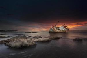 navio naufragou ao pôr do sol em chonburi tailândia foto