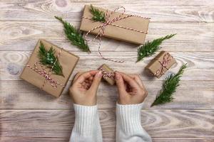 mãos de mulher decorando a caixa de presente de natal foto