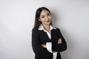 retrato de um chefe de menina asiática sorridente confiante vestindo terno preto em pé com os braços cruzados e olhando para a câmera isolada sobre fundo branco foto