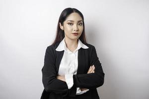 retrato de um chefe de menina asiática sorridente confiante vestindo terno preto em pé com os braços cruzados e olhando para a câmera isolada sobre fundo branco foto