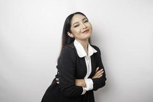 retrato de um chefe de menina asiática sorridente confiante vestindo terno preto em pé com os braços cruzados e olhando para a câmera isolada sobre fundo branco foto