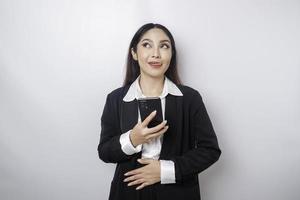 foto de uma jovem empresária com fome e excitada segurando seu telefone e se perguntando o que pedir comida saborosa isolada no fundo de cor branca