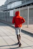 homem afro-americano corre ao longo da rua foto