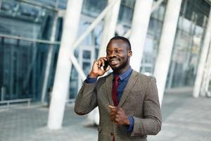 Elegante empresário negro afro-americano falando em seu smartphone