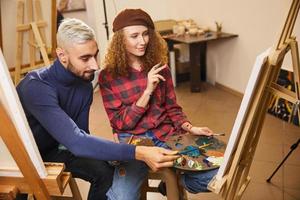 dois artistas elegantes desenham uma pintura a óleo foto