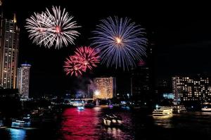 celebração de fogos de artifício no rio no céu escuro foto