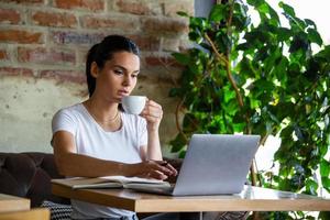 jovem empresária está trabalhando em uma lanchonete em seu break.woman fazendo uma pausa. curtindo o trabalho da cafeteria. fazendo negócios na cafeteria foto