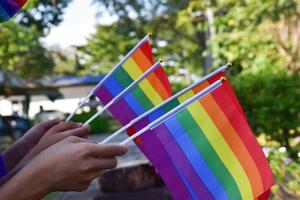 bandeiras do arco-íris, símbolo lgbt, segurando nas mãos, conceito para celebração da comunidade lgbt no mês do orgulho, junho de 2023, em todo o mundo. foto