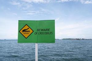 sinal de alerta de perigo de crocodilo que vive no mar foto